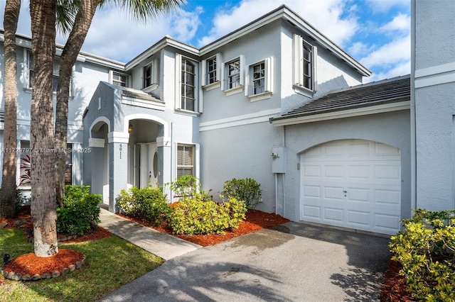 view of front of property featuring a garage, aphalt driveway, and stucco siding