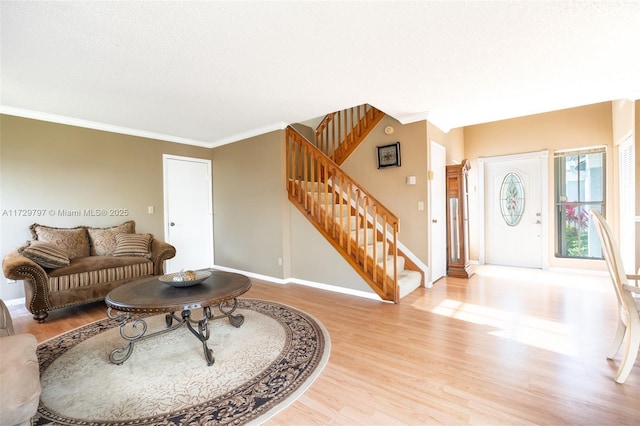 living room with crown molding, stairs, and wood finished floors