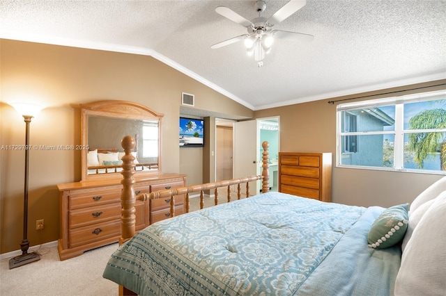 carpeted bedroom with a textured ceiling, a ceiling fan, visible vents, vaulted ceiling, and crown molding