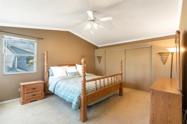 bedroom with crown molding, vaulted ceiling, a closet, and light colored carpet