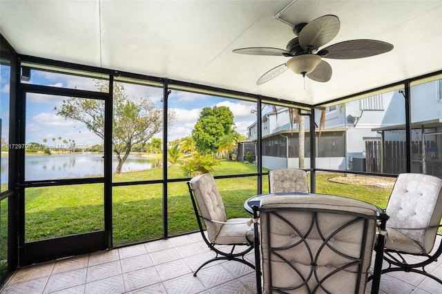 sunroom with a water view and ceiling fan