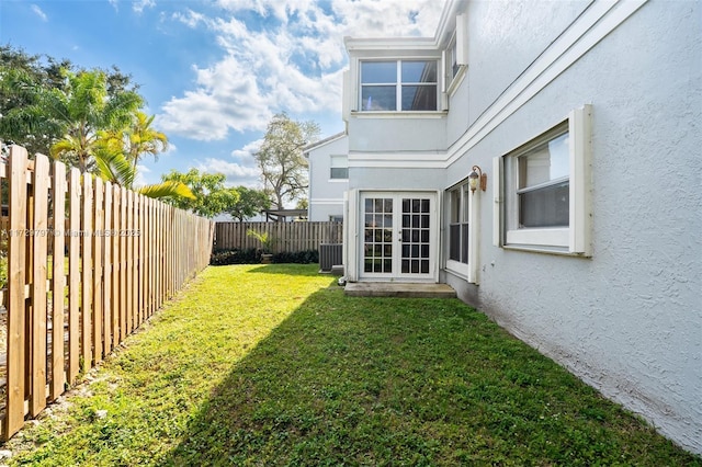 view of yard featuring french doors and a fenced backyard