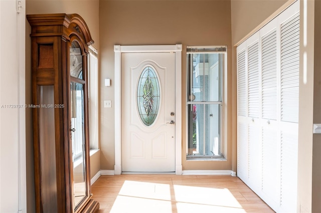 foyer entrance with light wood finished floors and baseboards