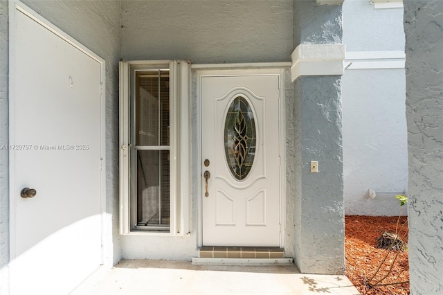 property entrance with stucco siding