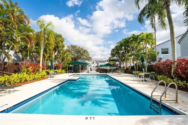 pool with a patio and fence