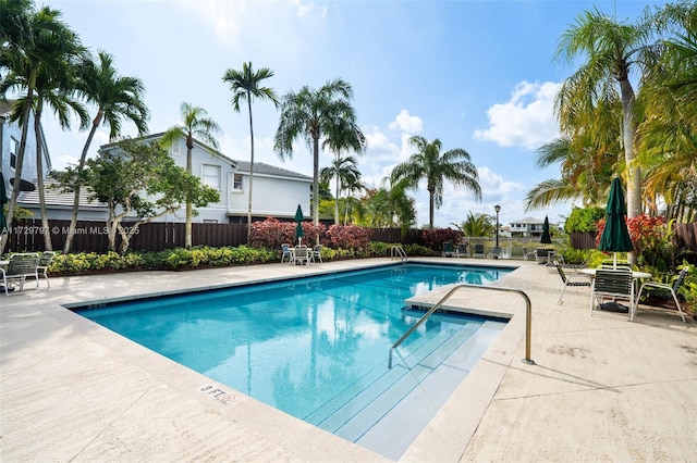 community pool featuring a patio and fence