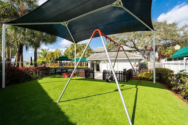 view of jungle gym with fence and a lawn