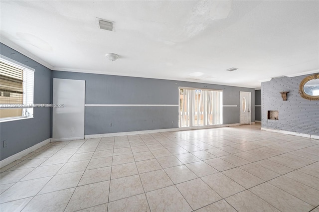 tiled empty room with a wealth of natural light, ornamental molding, a fireplace, and a textured ceiling