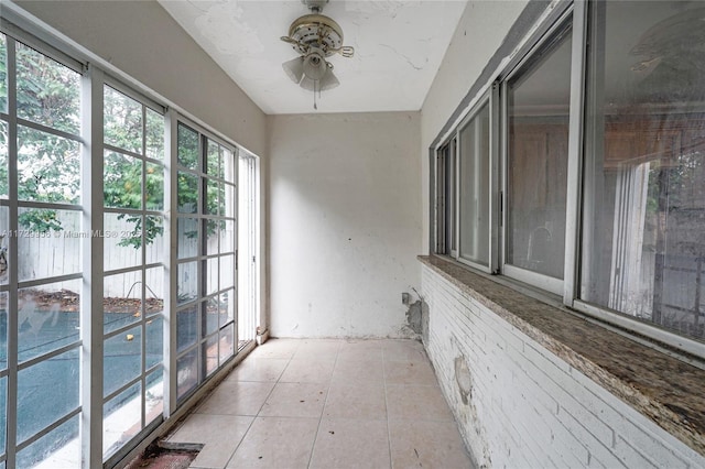 unfurnished sunroom with ceiling fan