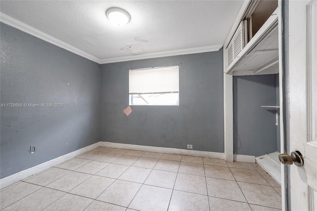 unfurnished room with crown molding, a textured ceiling, and light tile patterned floors