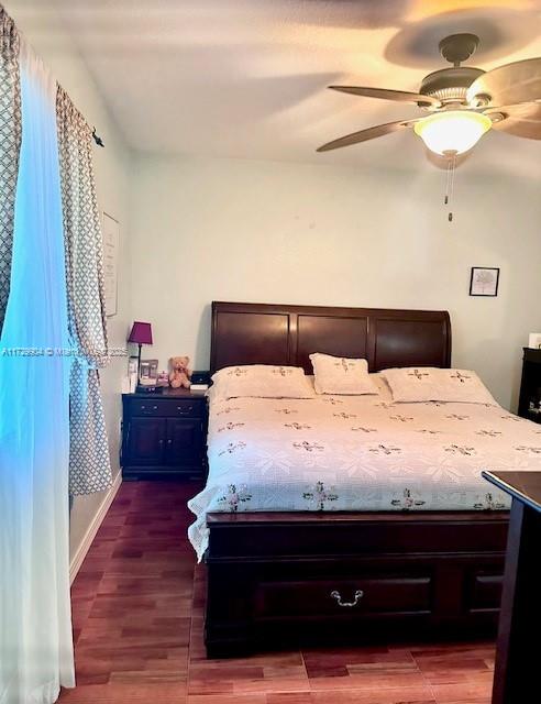 bedroom with dark wood-type flooring and ceiling fan