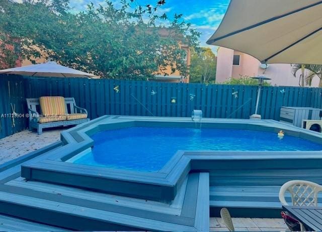 view of swimming pool featuring a jacuzzi