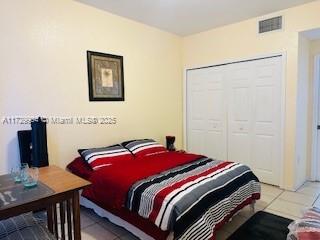 bedroom with a closet and light tile patterned floors