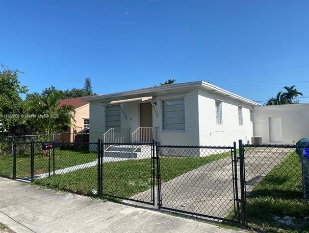 view of front of home with a front yard and central air condition unit