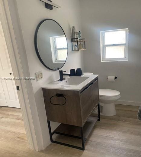 bathroom featuring vanity, hardwood / wood-style flooring, and toilet