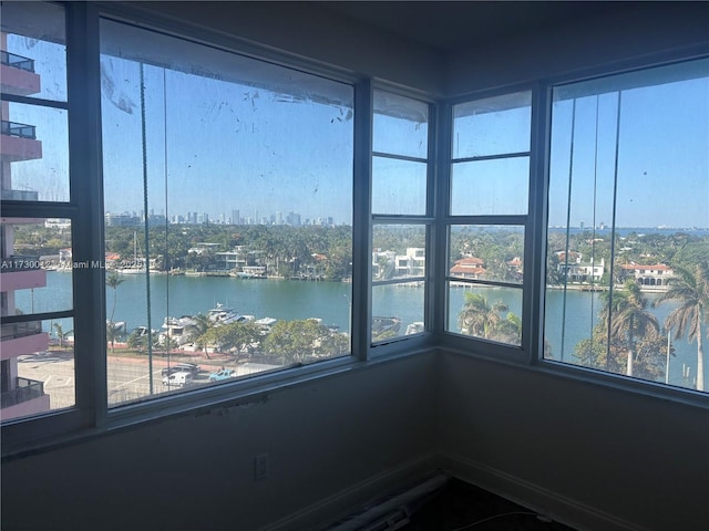 unfurnished sunroom featuring a water view