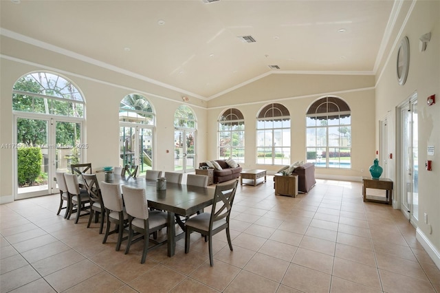 dining space featuring light tile patterned floors, visible vents, ornamental molding, and vaulted ceiling