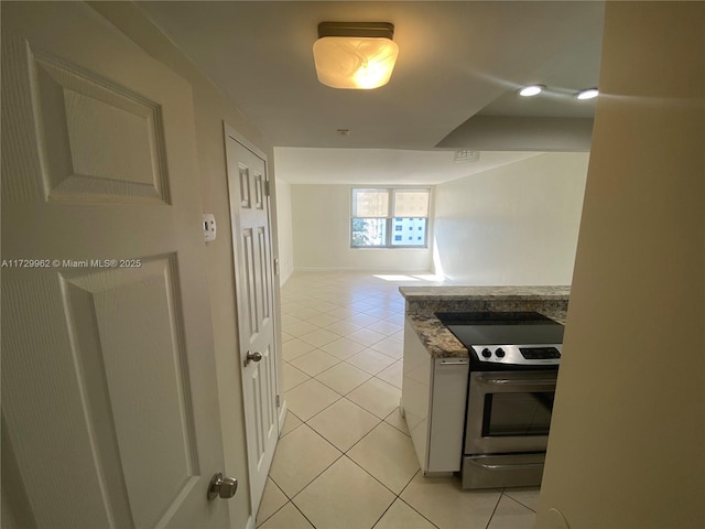 kitchen featuring electric stove, white cabinets, light tile patterned floors, and black electric cooktop