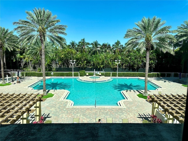 pool featuring fence, a patio, and a community hot tub