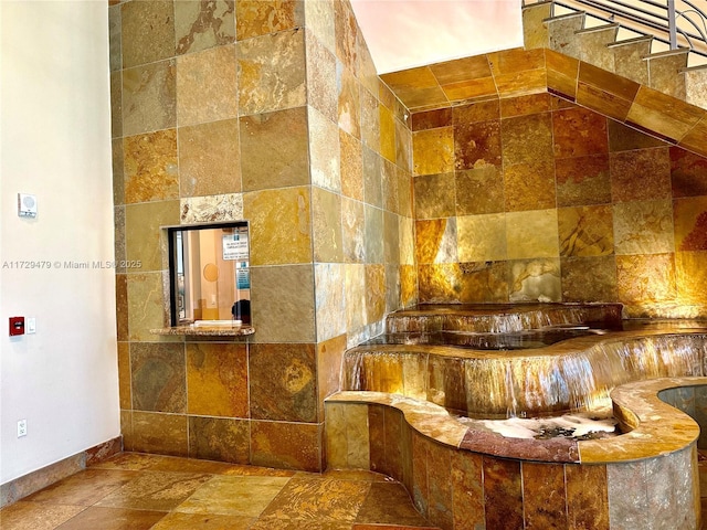 1755 E Hallandale Beach Blvd Unit 1605E, Hallandale Beach, FL 33009 - bathroom featuring baseboards and stone tile flooring