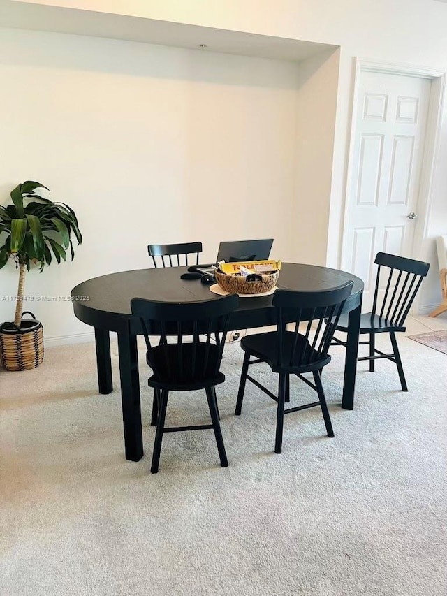 dining room with light colored carpet and baseboards