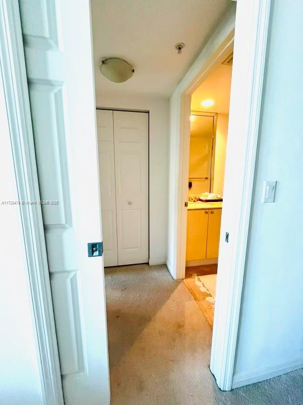 hallway with carpet and baseboards
