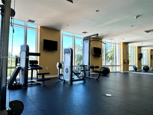 exercise room featuring a wall of windows, visible vents, and baseboards