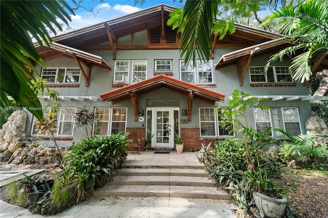 view of front of property featuring brick siding and stucco siding