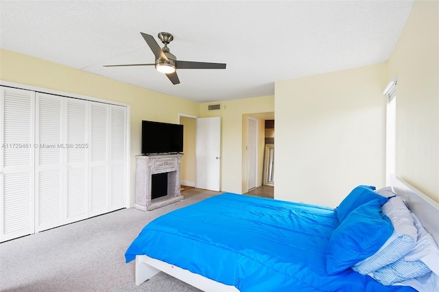 bedroom featuring a closet, ceiling fan, carpet flooring, and a textured ceiling