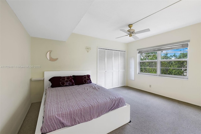 carpeted bedroom featuring ceiling fan and a closet