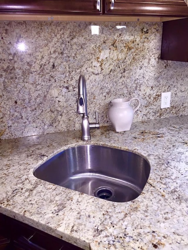 details featuring light stone counters and sink