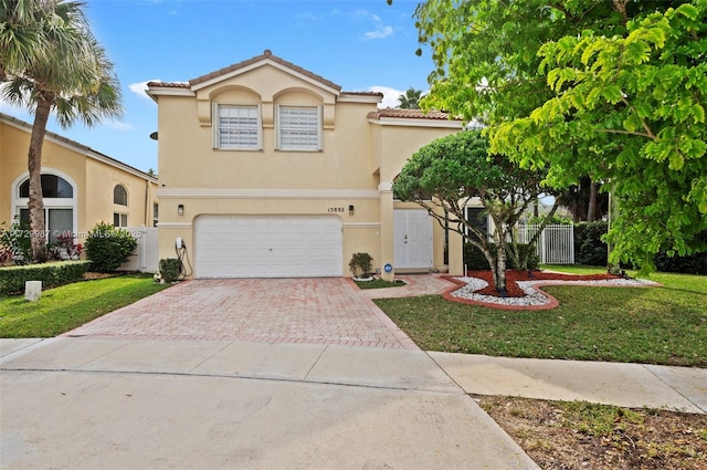 mediterranean / spanish-style house with a garage and a front lawn