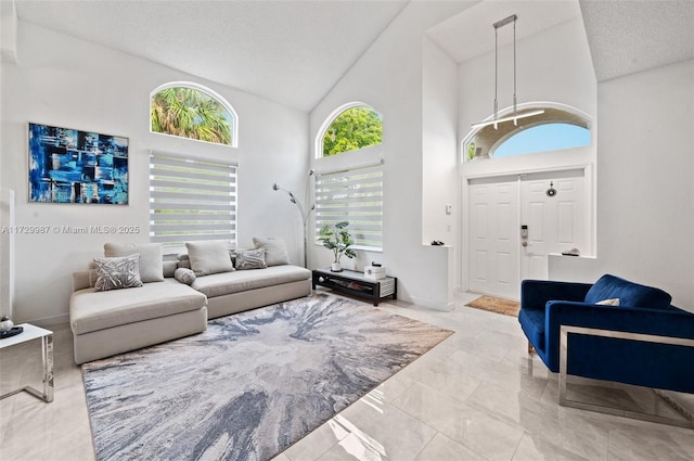 living room featuring high vaulted ceiling and a textured ceiling