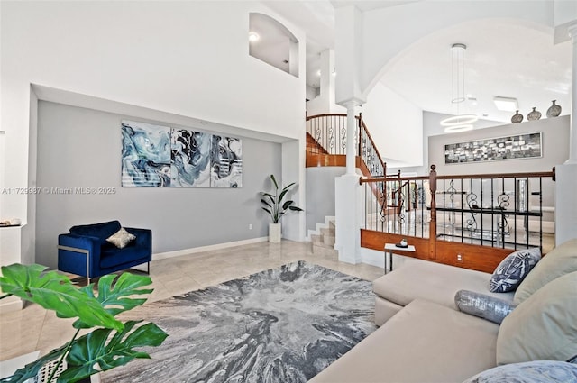 living room featuring ornate columns and a high ceiling