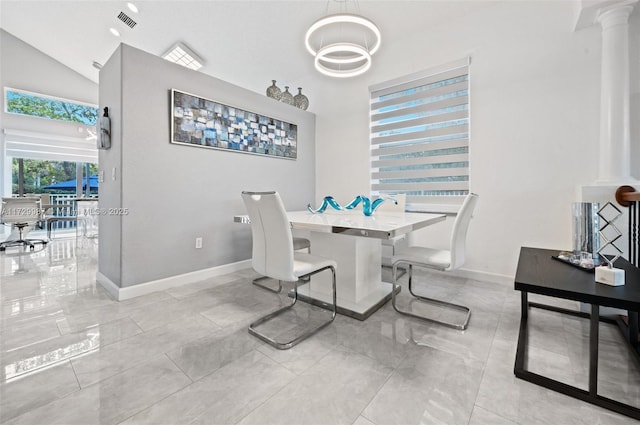 dining space featuring high vaulted ceiling and decorative columns