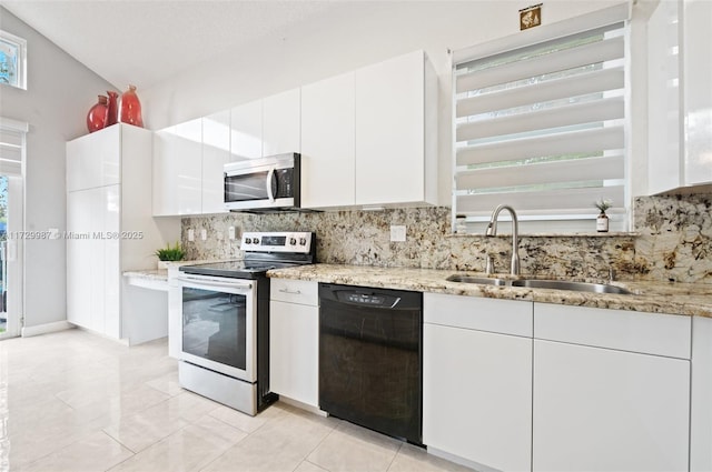 kitchen featuring appliances with stainless steel finishes, tasteful backsplash, sink, white cabinets, and light stone counters