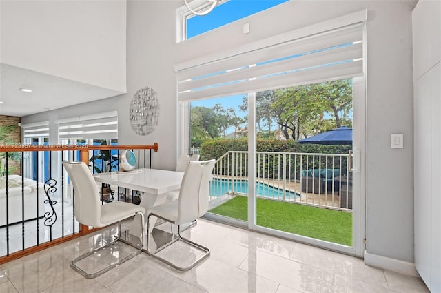 dining space featuring a towering ceiling and a wealth of natural light