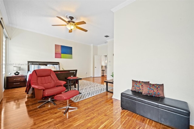 bedroom with light hardwood / wood-style flooring, ornamental molding, and ceiling fan