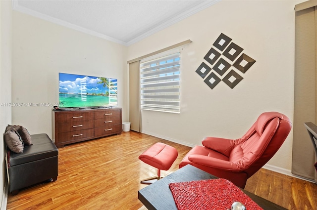 sitting room with light hardwood / wood-style flooring and ornamental molding