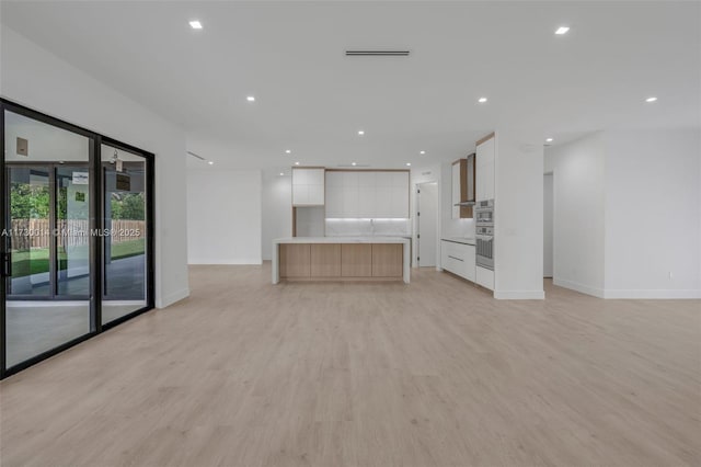 unfurnished living room with light hardwood / wood-style flooring