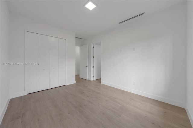 unfurnished bedroom with a closet and light hardwood / wood-style flooring