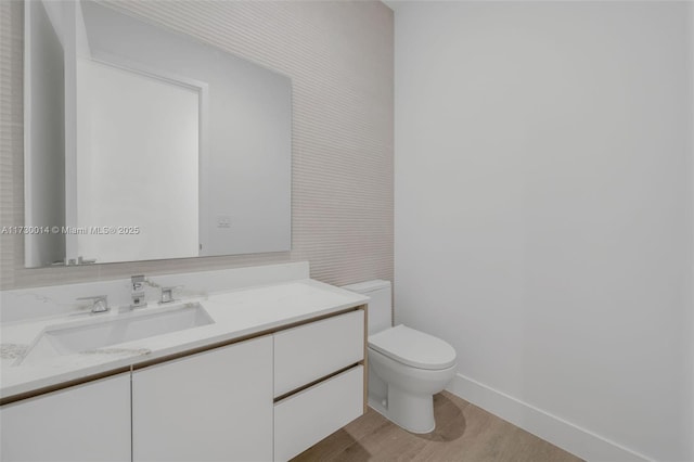 bathroom featuring vanity, toilet, and hardwood / wood-style floors