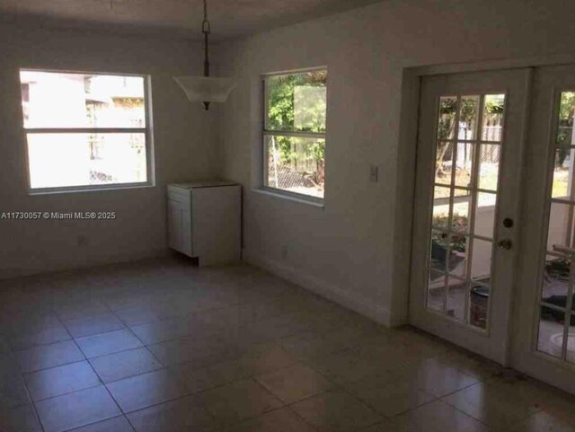 unfurnished dining area featuring tile patterned floors