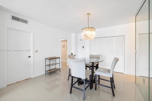 tiled dining room with a notable chandelier