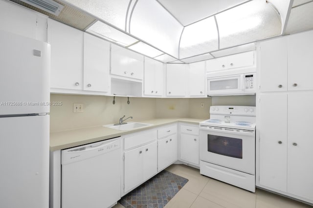 kitchen with sink, white appliances, white cabinets, and light tile patterned flooring