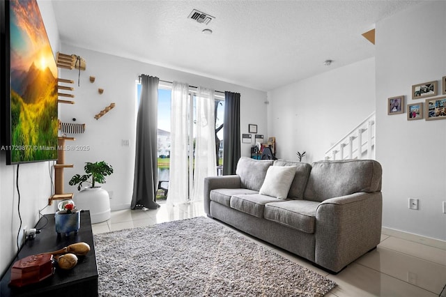 tiled living room featuring a textured ceiling