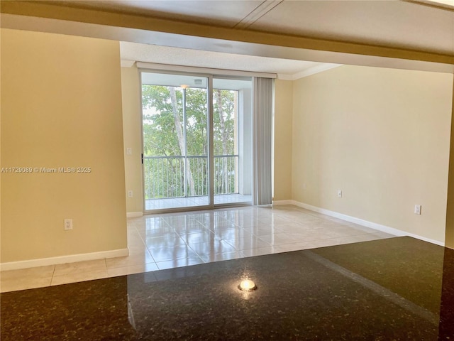 empty room with expansive windows and light tile patterned flooring