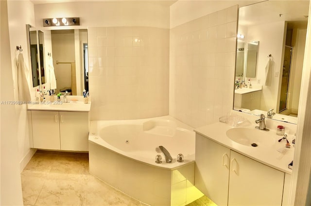 bathroom with vanity and tiled tub