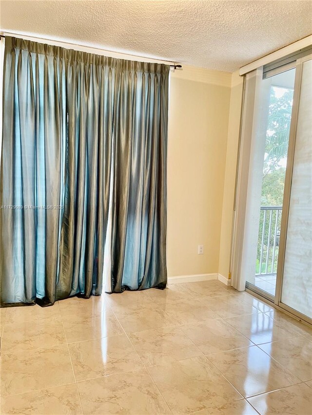 spare room featuring a wall of windows and a textured ceiling