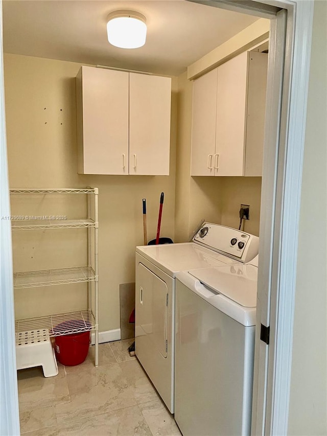 clothes washing area featuring independent washer and dryer and cabinets